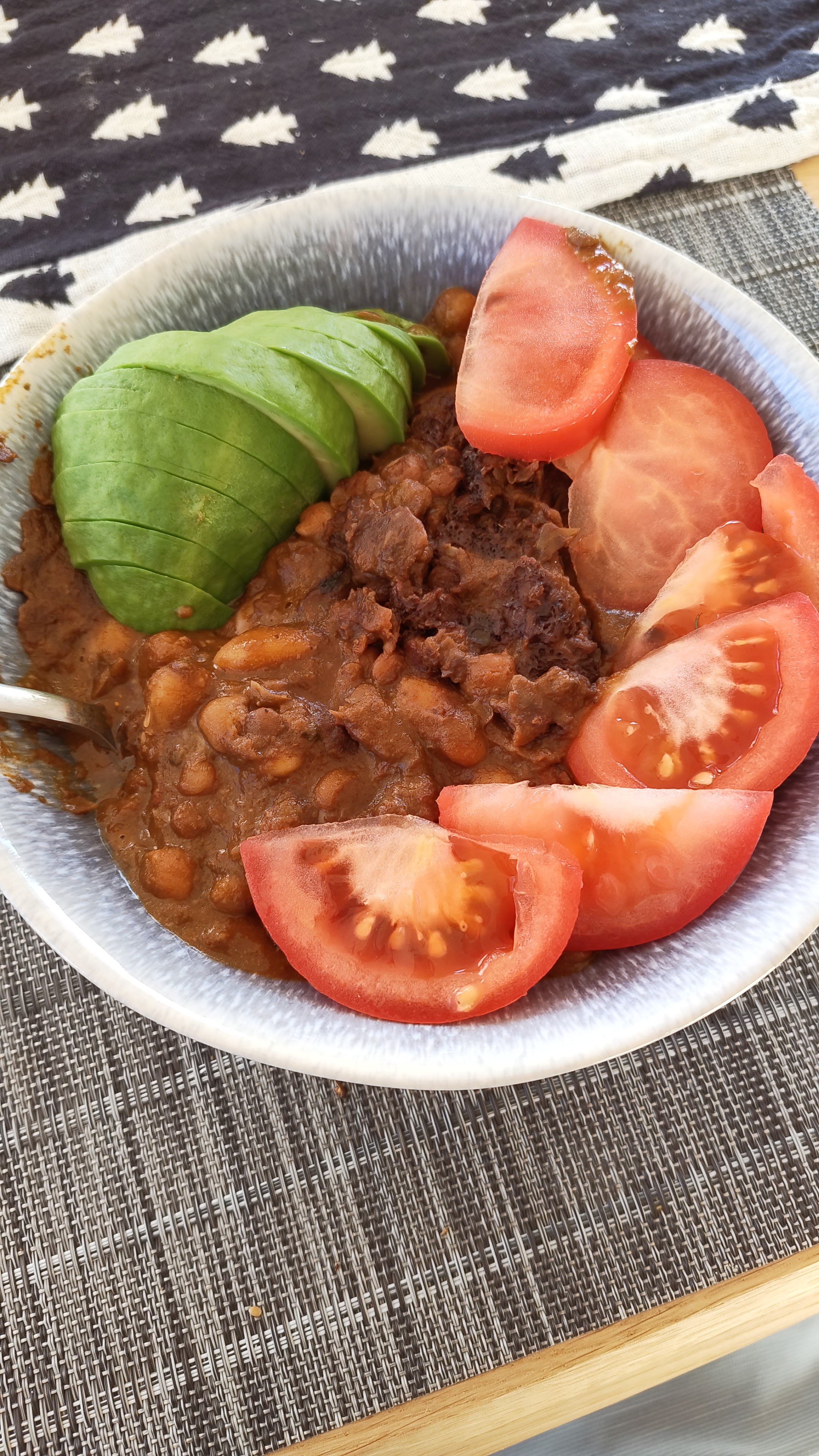 Bean stew served with avocado and fresh tomato